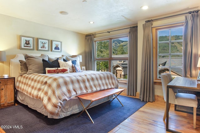 bedroom with multiple windows and light hardwood / wood-style flooring