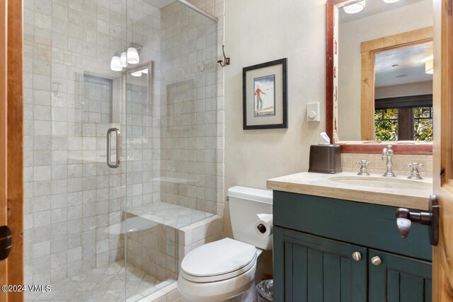 bathroom with vanity, toilet, an enclosed shower, and backsplash