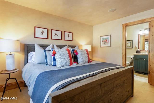 bedroom with light carpet and ensuite bath