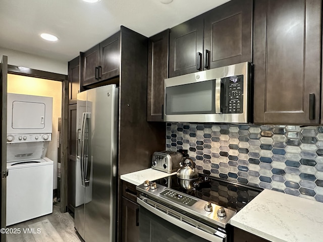 120 Offerson Rd Unit A160, Beaver Creek, CO 81620 - kitchen with stainless steel appliances, stacked washer / drying machine, light wood-style flooring, tasteful backsplash, and dark brown cabinets
