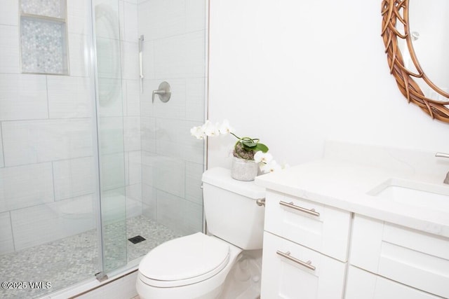 full bathroom with a stall shower, vanity, and toilet