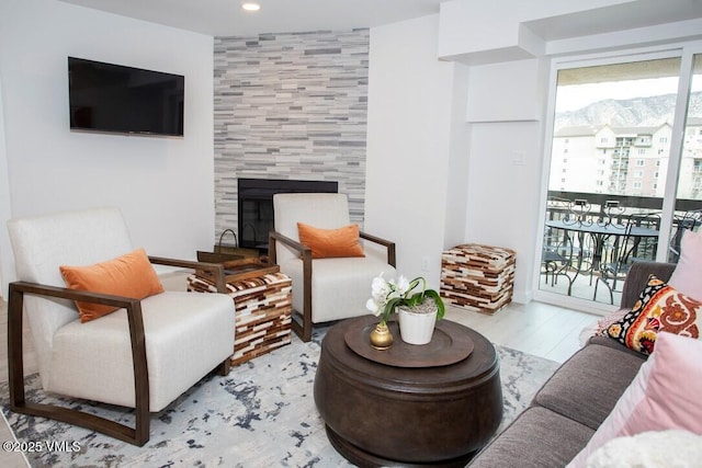 living area with recessed lighting, wood finished floors, and a tile fireplace