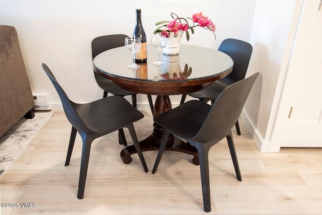 dining area featuring light wood-style floors and baseboards