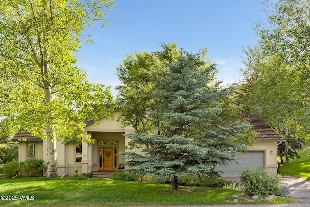 2 Anvil Cir, Edwards, CO 81632 - obstructed view of property with stucco siding, a front yard, concrete driveway, and a garage