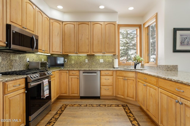 2 Anvil Cir, Edwards, CO 81632 - kitchen featuring appliances with stainless steel finishes, inlaid floor details, light stone counters, light brown cabinets, and recessed lighting