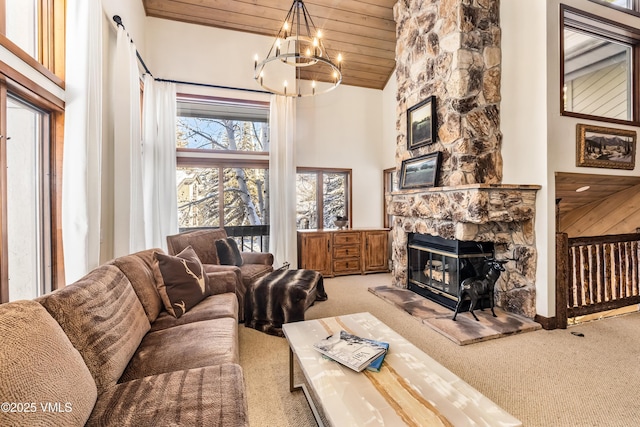 carpeted living room featuring high vaulted ceiling, a fireplace, wooden ceiling, and a chandelier