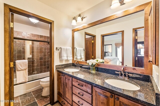 full bathroom with vanity, toilet, and combined bath / shower with glass door