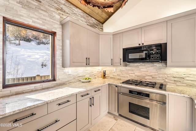 kitchen with stainless steel appliances, light stone countertops, vaulted ceiling, and backsplash