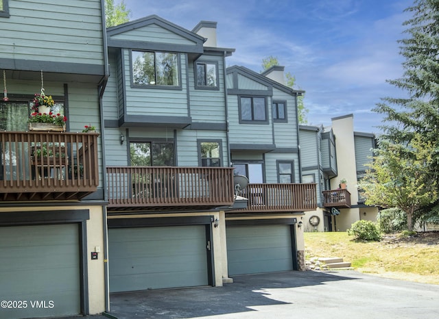 2403 Draw Spur Unit 2, Avon, CO 81620 - rear view of house with an attached garage, driveway, a chimney, and a balcony