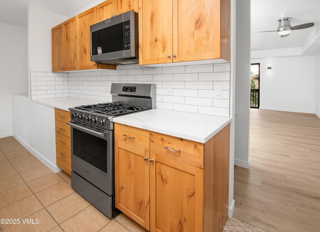 2403 Draw Spur Unit 2, Avon, CO 81620 - kitchen featuring appliances with stainless steel finishes, light countertops, backsplash, a ceiling fan, and light wood-type flooring