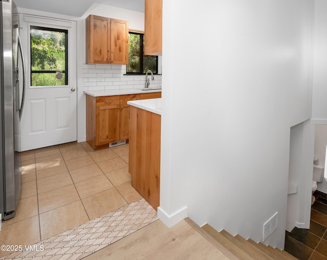 2403 Draw Spur Unit 2, Avon, CO 81620 - kitchen featuring freestanding refrigerator, light countertops, backsplash, and light tile patterned floors