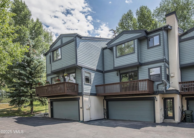 2403 Draw Spur Unit 2, Avon, CO 81620 - rear view of property featuring a garage, asphalt driveway, a chimney, and a balcony