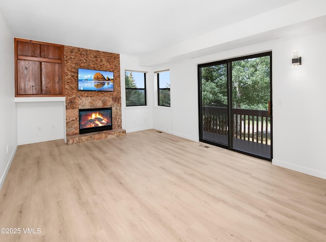 2403 Draw Spur Unit 2, Avon, CO 81620 - unfurnished living room featuring a large fireplace and light wood-style flooring