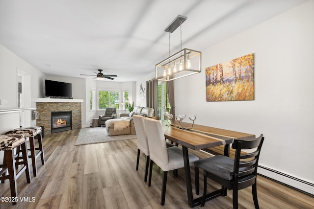601 Crazy Horse Cir Unit 601, Edwards, CO 81632 - dining area with a baseboard heating unit, wood finished floors, ceiling fan, and a fireplace