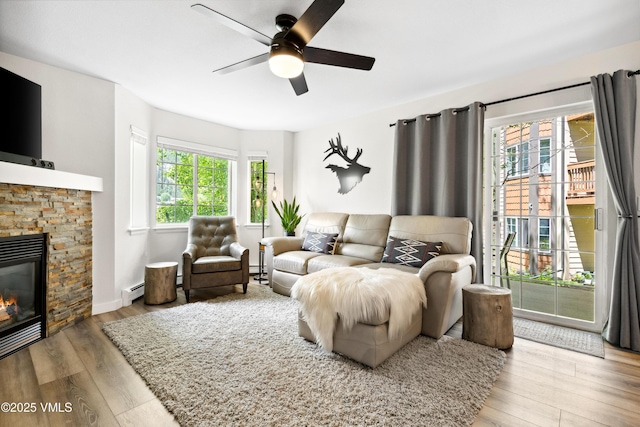 601 Crazy Horse Cir Unit 601, Edwards, CO 81632 - living room featuring a ceiling fan, wood finished floors, a fireplace, and a baseboard heating unit