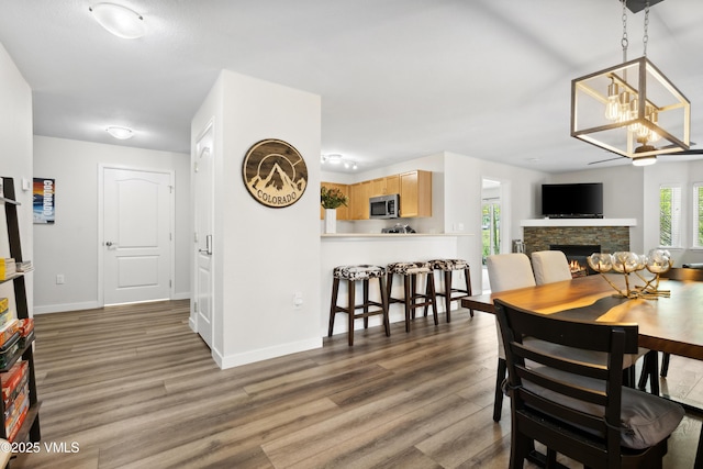 601 Crazy Horse Cir Unit 601, Edwards, CO 81632 - dining space featuring a chandelier, wood finished floors, and a stone fireplace