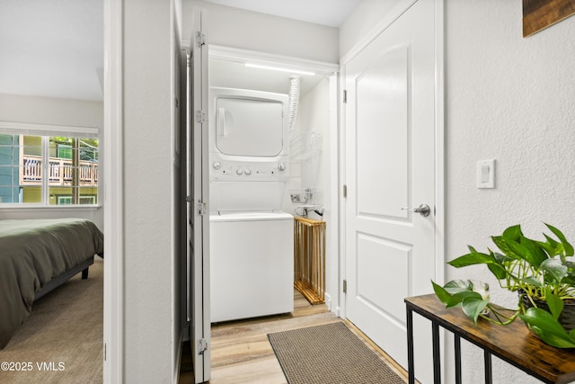 601 Crazy Horse Cir Unit 601, Edwards, CO 81632 - laundry room featuring estacked washer and dryer, a textured wall, and light wood-type flooring