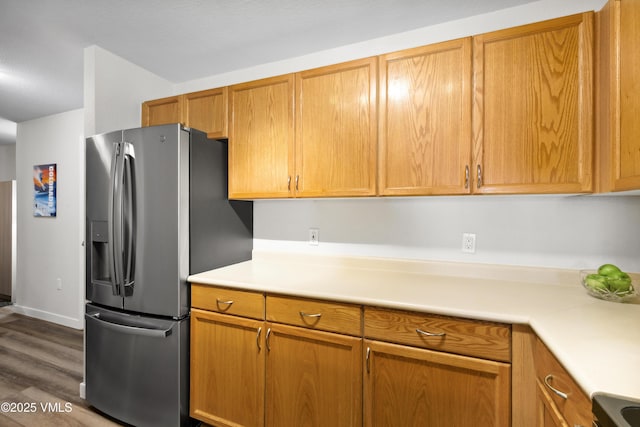 601 Crazy Horse Cir Unit 601, Edwards, CO 81632 - kitchen with stainless steel fridge, light countertops, dark wood-style flooring, and brown cabinetry