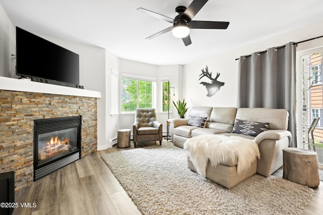 601 Crazy Horse Cir Unit 601, Edwards, CO 81632 - living area with a ceiling fan, wood finished floors, a stone fireplace, and a baseboard radiator