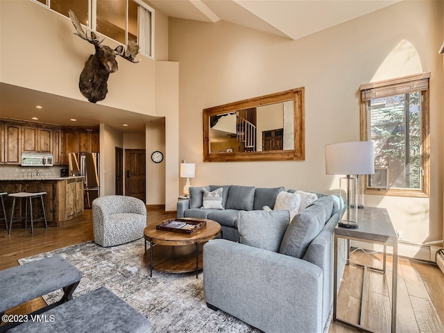 living area with wood finished floors and a towering ceiling