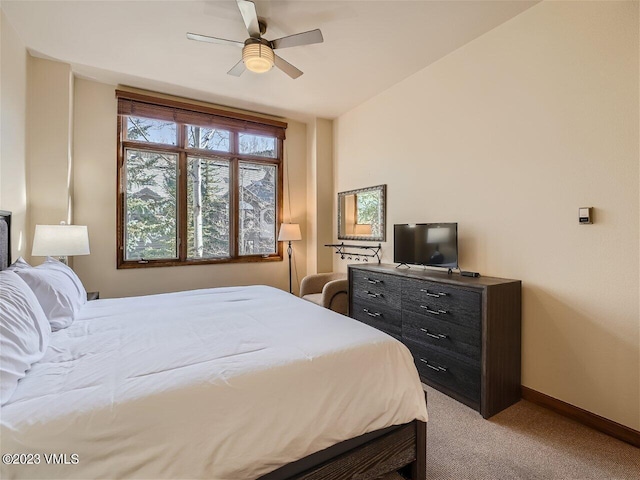 carpeted bedroom with ceiling fan and baseboards