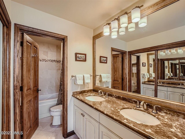 bathroom featuring tile patterned flooring, double vanity, toilet, and a sink