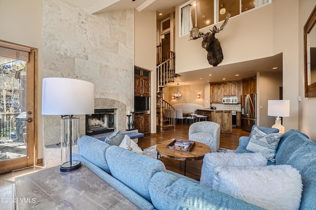 living room with stairs, a tiled fireplace, recessed lighting, and dark wood finished floors