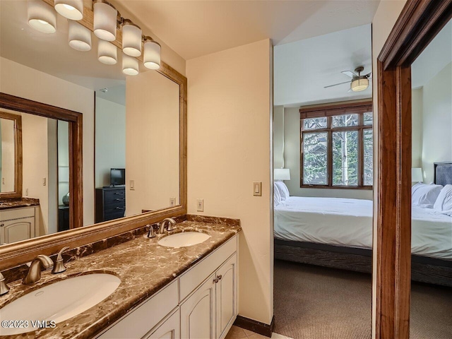 ensuite bathroom with a sink, double vanity, ceiling fan, and ensuite bathroom