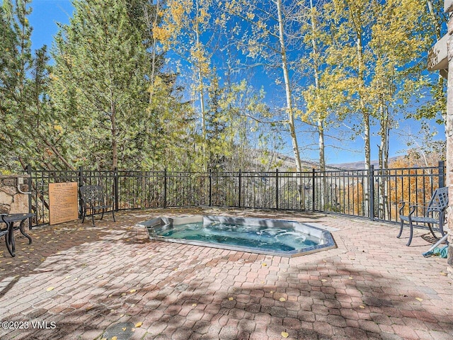 view of pool featuring a patio area, an in ground hot tub, and fence