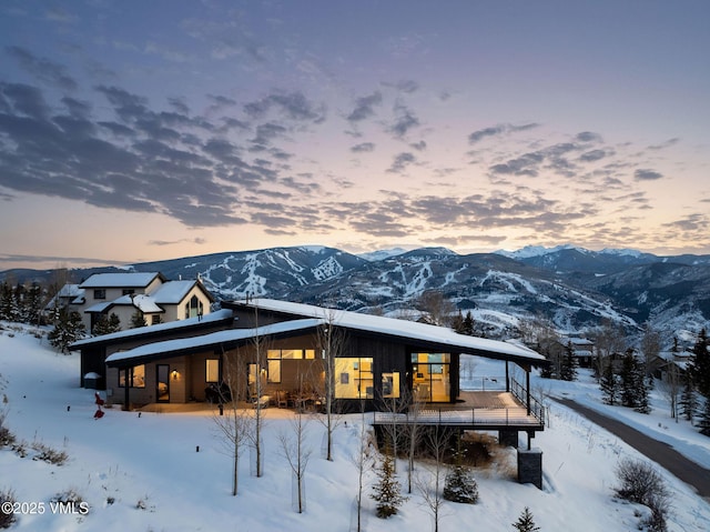 snow covered house featuring a mountain view