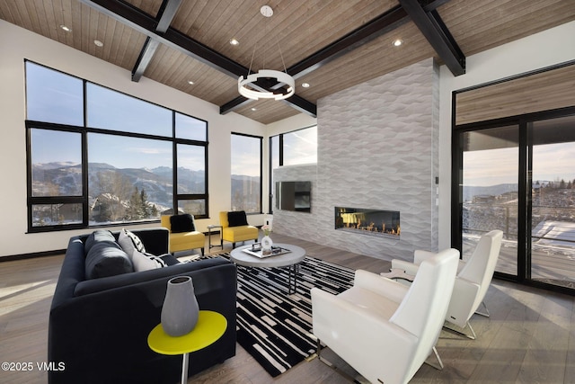 living room featuring wood ceiling, a mountain view, hardwood / wood-style flooring, and a fireplace