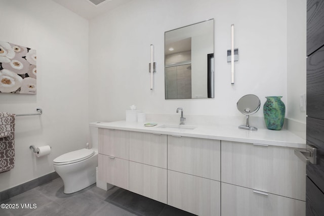 bathroom featuring walk in shower, vanity, toilet, and tile patterned flooring