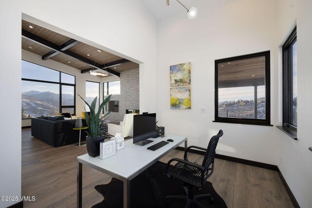 office with a high ceiling, dark wood-type flooring, wooden ceiling, and beam ceiling