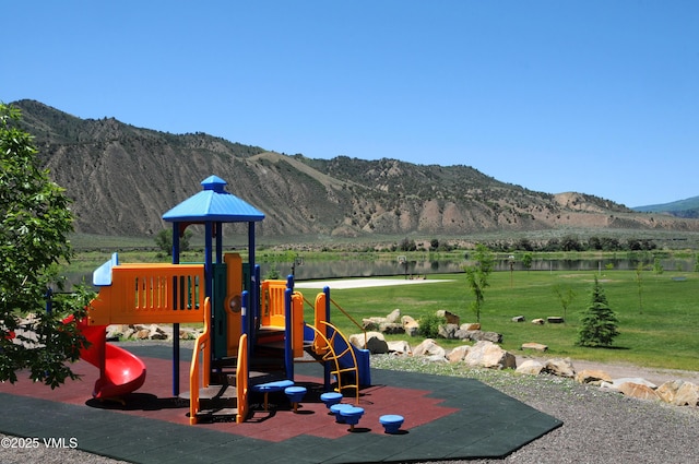 view of play area featuring a yard and a water and mountain view