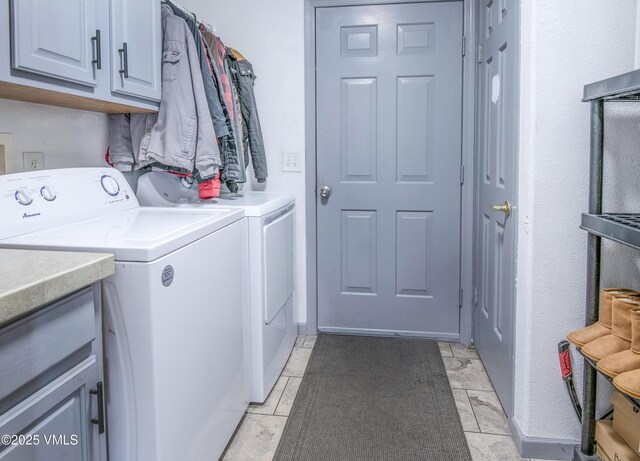 laundry area with independent washer and dryer and cabinets