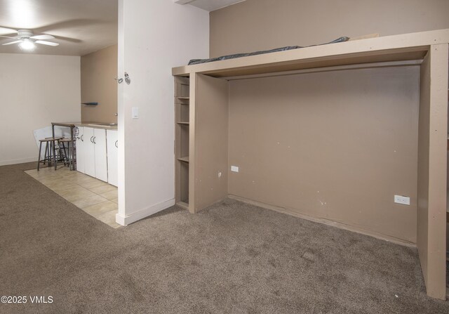 empty room featuring ceiling fan and light colored carpet