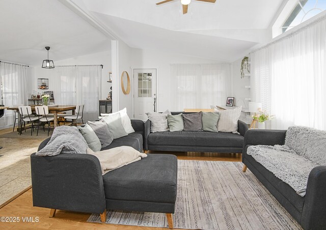 living room featuring light hardwood / wood-style flooring, vaulted ceiling, and ceiling fan