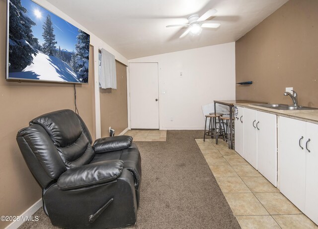 living room featuring lofted ceiling, sink, light carpet, and ceiling fan