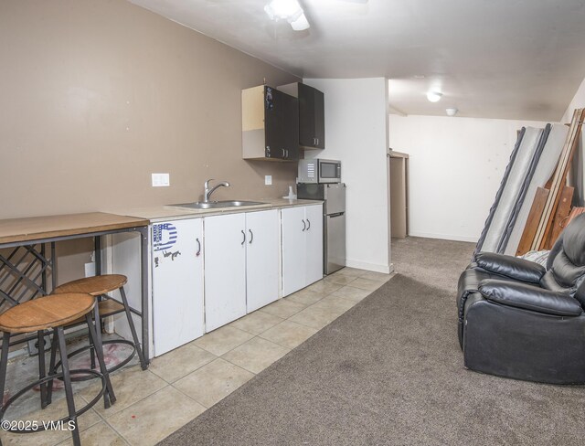 kitchen with white cabinetry, appliances with stainless steel finishes, sink, and light carpet