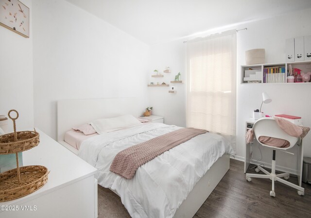 bedroom with dark wood-type flooring