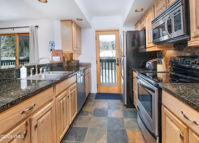 kitchen featuring sink, crown molding, appliances with stainless steel finishes, backsplash, and dark stone counters