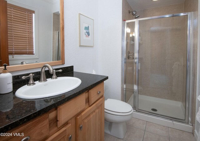 bathroom featuring an enclosed shower, vanity, tile patterned floors, and toilet