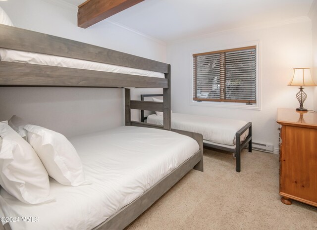 carpeted bedroom with a baseboard heating unit, beam ceiling, and ornamental molding