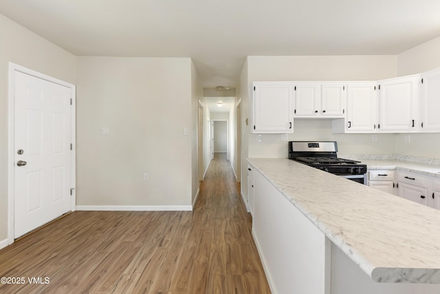 423 Second St, Gypsum, CO 81637 - kitchen featuring gas range, light wood finished floors, light countertops, and white cabinetry