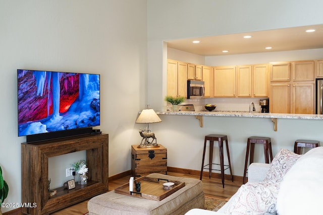 living room with recessed lighting, baseboards, and wood finished floors