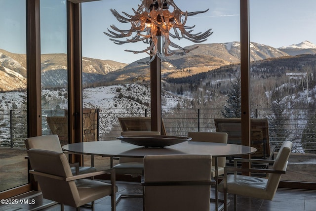 dining space with a mountain view, floor to ceiling windows, and a chandelier