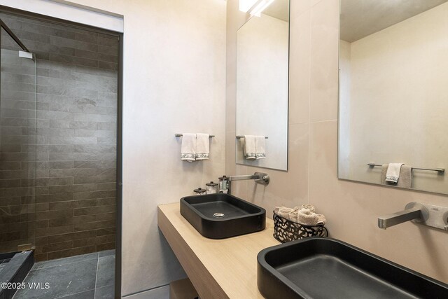 bathroom with sink and a tile shower