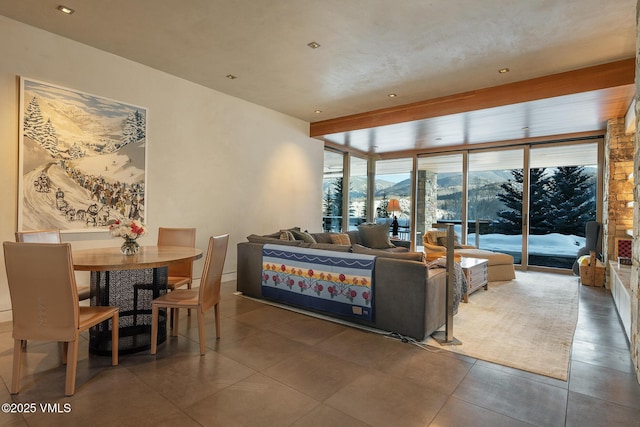 living room featuring a wall of windows, a mountain view, and dark tile patterned flooring