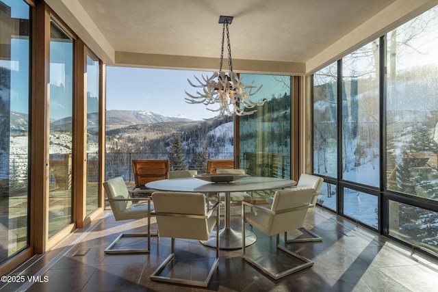 sunroom with a chandelier, a healthy amount of sunlight, and a mountain view