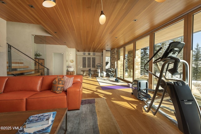 workout room with wood-type flooring, wood ceiling, and a wall of windows